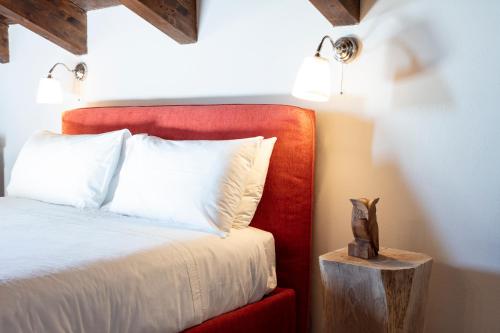 a bedroom with a bed with a red headboard and a table at Cascina il Faggio Country House in Mosso Santa Maria