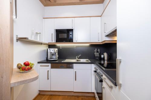 a kitchen with white cabinets and a bowl of fruit at Landhaus Dorfbäck in Stumm