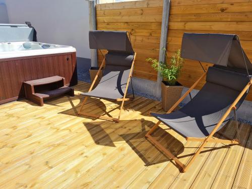 two chairs and a bath tub in a room at A Fleur de Spa : Maison chaleureuse avec spa privatif et billard. in Coulogne