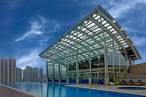 a large swimming pool in a large building at Nina Hotel Tsuen Wan West in Hong Kong