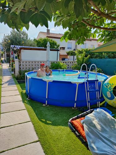 un homme et un enfant dans un bassin dans l'herbe dans l'établissement Pavillon de Diane, à Prades