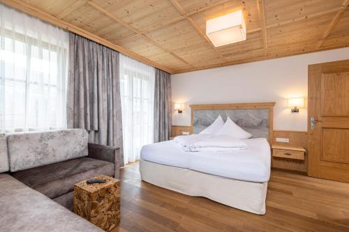 a hotel room with a bed and a couch at Landhaus Dorfbäck in Stumm