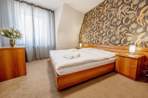 a bedroom with a bed with a large wall at City Hotel in Piešťany