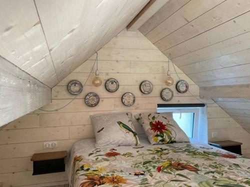 - un lit dans une chambre avec des horloges murales dans l'établissement La petite maison d’Orphée, à Marmagne