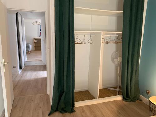 Cette chambre dispose de rideaux verts et d'un couloir. dans l'établissement Charmant appartement entre Camargue et Alpilles, à Tarascon