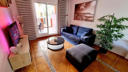 a living room with a blue couch and a table at Villas de Almerimar Golf in El Ejido