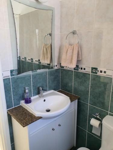 a bathroom with a sink and a mirror and a toilet at Protaras sea view Villa with private pool in Protaras