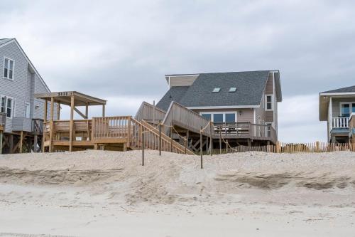 a row of houses on the beach next to the sand at Wahoo by Oak Island Accommodations in Oak Island