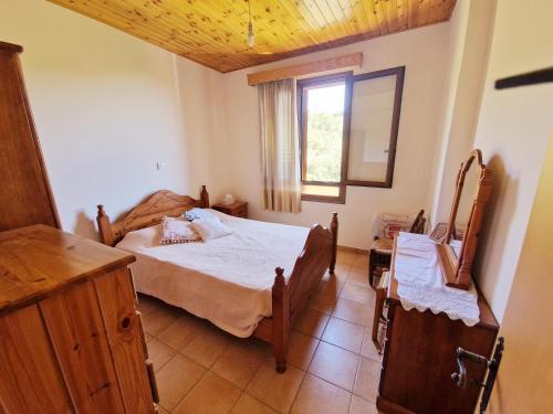 um quarto com uma cama e uma janela em Arsos Village Apartment em Arsos