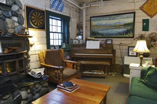a living room with a piano and a couch at Talkeetna Roadhouse in Talkeetna