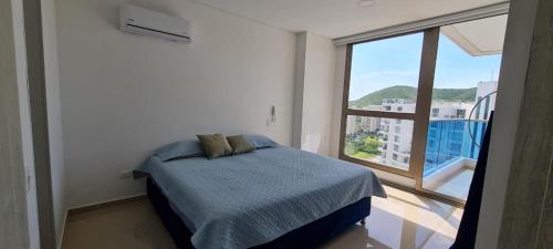 a bedroom with a bed and a large window at Club de Playa Samaria - T1 APTO 1705, Santamarta in Santa Marta