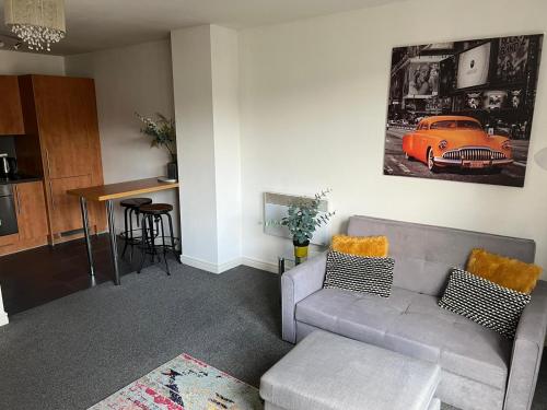 uma sala de estar com um sofá e um carro na parede em City centre 1 bed apartment with free on site parking with CCTV by Lets Relocations em Birmingham