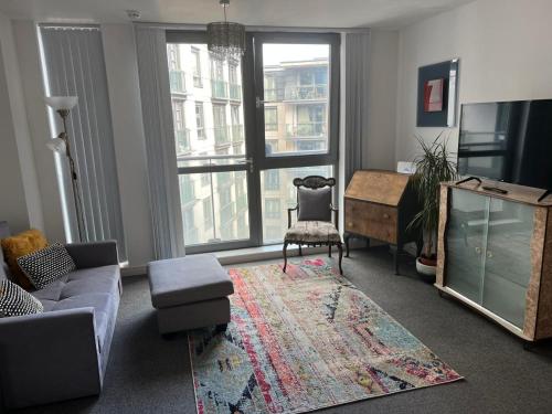 a living room with a couch and a chair at Modern city centre 1 bed apartment with gym access & free parking by Lets Relocations in Birmingham