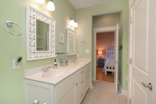 a bathroom with a sink and a mirror at Turtle Watch Too by Oak Island Accommodations in Caswell Beach
