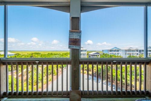 a balcony with a view of a beach and buildings at Turtle Watch Too by Oak Island Accommodations in Caswell Beach