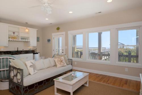 a living room with a couch and a table at Turtle Watch Too by Oak Island Accommodations in Caswell Beach