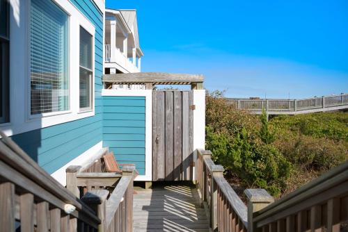a house with a wooden deck and a window at Turtle Watch Too by Oak Island Accommodations in Caswell Beach