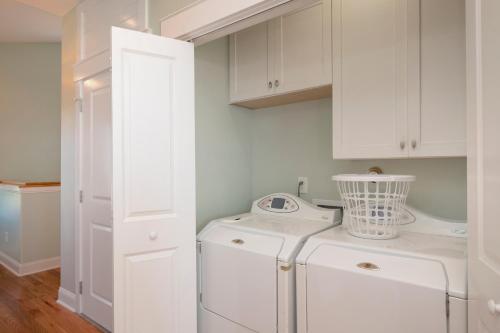 a white washer and dryer in a white laundry room at Turtle Watch Too by Oak Island Accommodations in Caswell Beach
