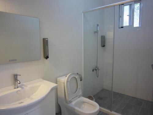 a bathroom with a toilet and a sink and a shower at Amy Walker B&B in Taimali