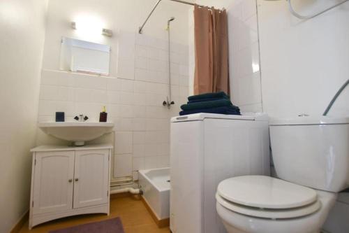 a white bathroom with a toilet and a sink at Le P'tit bec ✹ Plage ✹ in Saint-Hilaire-de-Riez