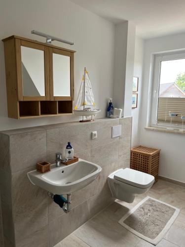 a bathroom with a sink and a toilet at Haus Luca Fuhlendorf in Fuhlendorf