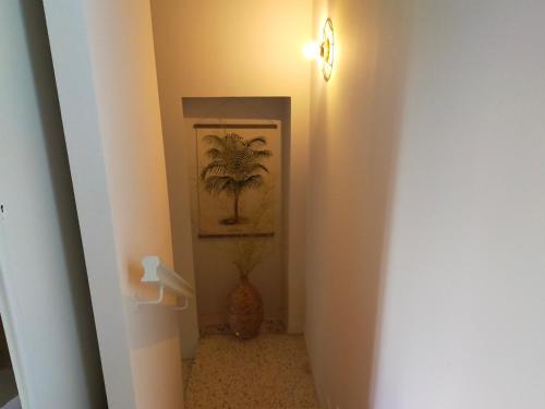 a hallway with a doorway with a palm tree painting at GITE LE TILLEUL in Mormoiron