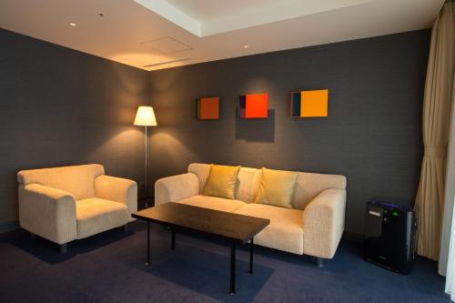 a living room with two chairs and a couch and a table at The Gate Hotel Kaminarimon by Hulic in Tokyo