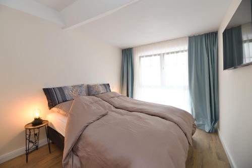 a bedroom with a large bed with a window at Das schiefe Haus - Wohnung "Weinlage" in Heppenheim an der Bergstrasse