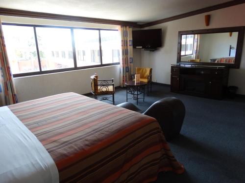 a hotel room with a bed and a desk and window at Hotel Lerma in Lerma de Villada