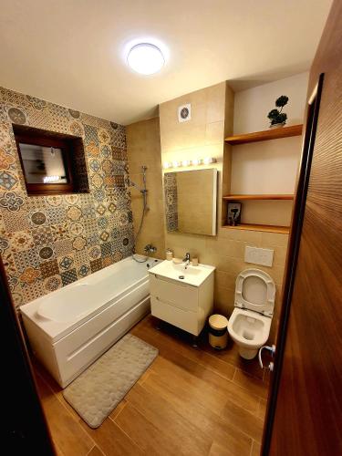 a bathroom with a tub and a sink and a toilet at Casa Maria Mamaia Nord in Mamaia Sat/Năvodari