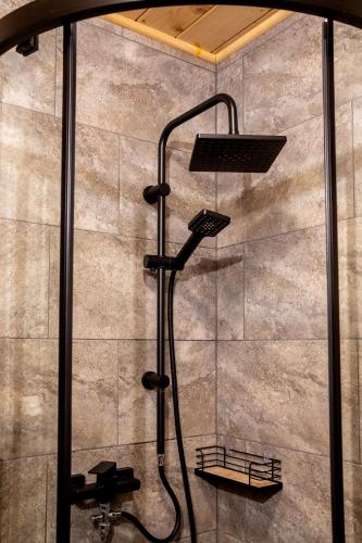a shower with a shower head in a bathroom at Domek Przekolec in Szaflary