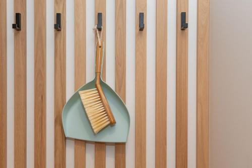 a wooden brush on a plate on a wall at VANEA - Alp Relax Guesthouse in Chienes
