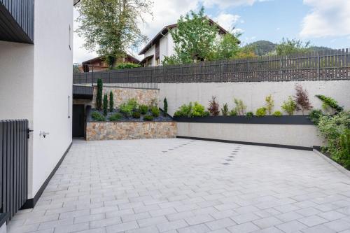 a courtyard in a house with a white wall and plants at VANEA - Alp Relax Guesthouse in Chienes