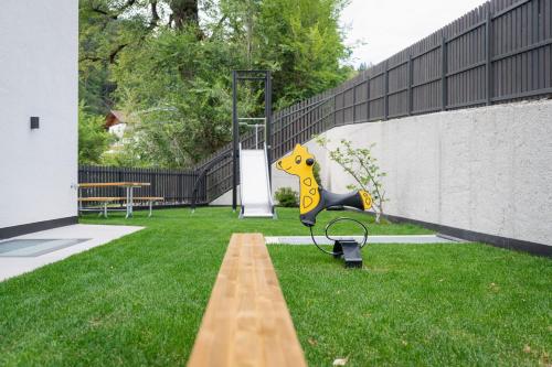 a bench in the grass next to a fence at VANEA - Alp Relax Guesthouse in Chienes