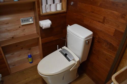 un bagno con pareti in legno e servizi igienici bianchi. di Guest House Miei - Vacation STAY 87536v a Nagahama