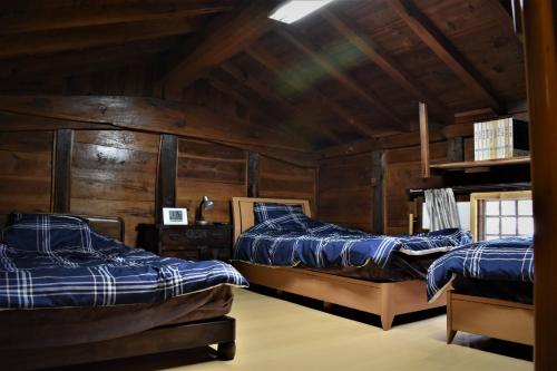 Duas camas num quarto com paredes de madeira em Guest House Miei - Vacation STAY 87547v em Nagahama