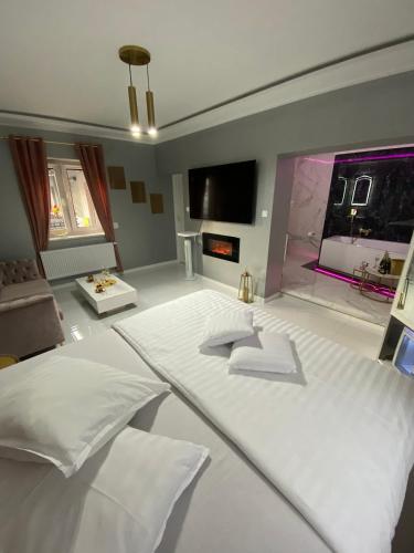 Schlafzimmer mit einem weißen Bett und einem großen Fenster in der Unterkunft Apartament "Prezydencki" Centrum z dużą wanną dla Dwojga in Gniezno