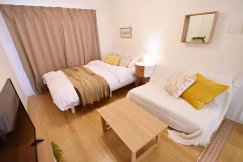 Cette petite chambre comprend deux lits et une télévision. dans l'établissement Mishku onna - Vacation STAY 88056v, à Baba