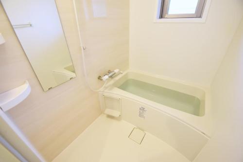 La salle de bains blanche est pourvue d'un lavabo et d'un miroir. dans l'établissement Mishku onna - Vacation STAY 88056v, à Baba