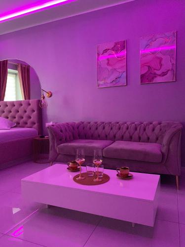a purple living room with a couch and a table at Apartament "Prezydencki" Centrum z dużą wanną dla Dwojga in Gniezno