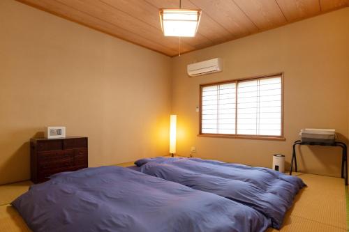 a bedroom with a large bed and a window at guesthouse UZU Sado - Vacation STAY 90684v in Sado