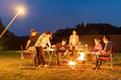 佐渡市にあるguesthouse UZU Sado - Vacation STAY 90684vの火の周りに座る人々