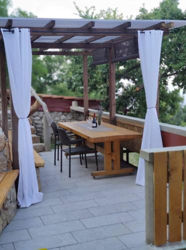 a wooden table and chairs on a patio at Počitniška hiša Morski pogled in Mošćenička Draga