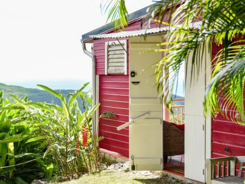 a red and white shed with a red door at Beausejour Guest House in Pointe-Noire