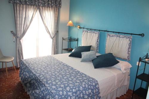 een slaapkamer met een bed met blauwe muren en een raam bij Apartamento Centro Murcia in Murcia