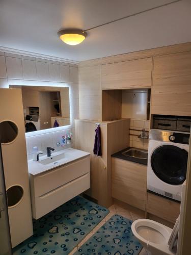 una pequeña cocina con fregadero y microondas en Sentrumsleilighet med gratis parkering til leie en Arendal