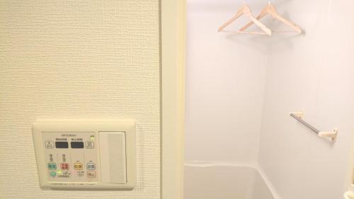 uma casa de banho com um dispensador de sabão na parede em Carsail Sole - Vacation STAY 13225 em Saitama