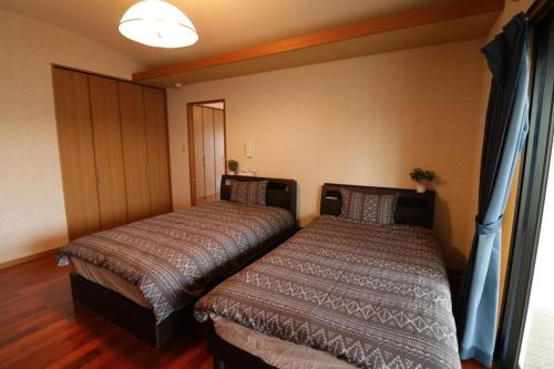 En eller flere senge i et værelse på Ugana Villa Ginowan - Vacation STAY 13237
