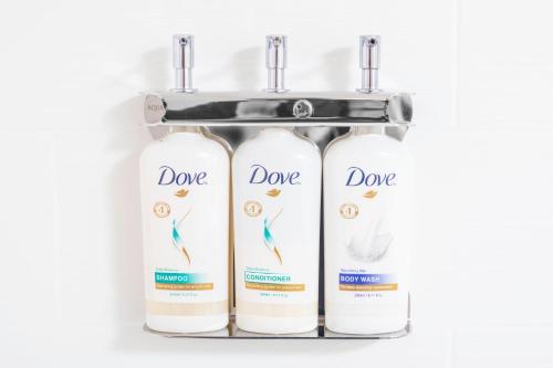 three bottles of dong shampoo and conditioner on a shelf at Holiday Inn Express and Suites Atlanta-Johns Creek by IHG in Johns Creek