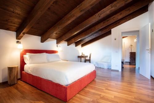 a bedroom with a large bed in a room with wooden ceilings at Cascina il Faggio Country House in Mosso Santa Maria